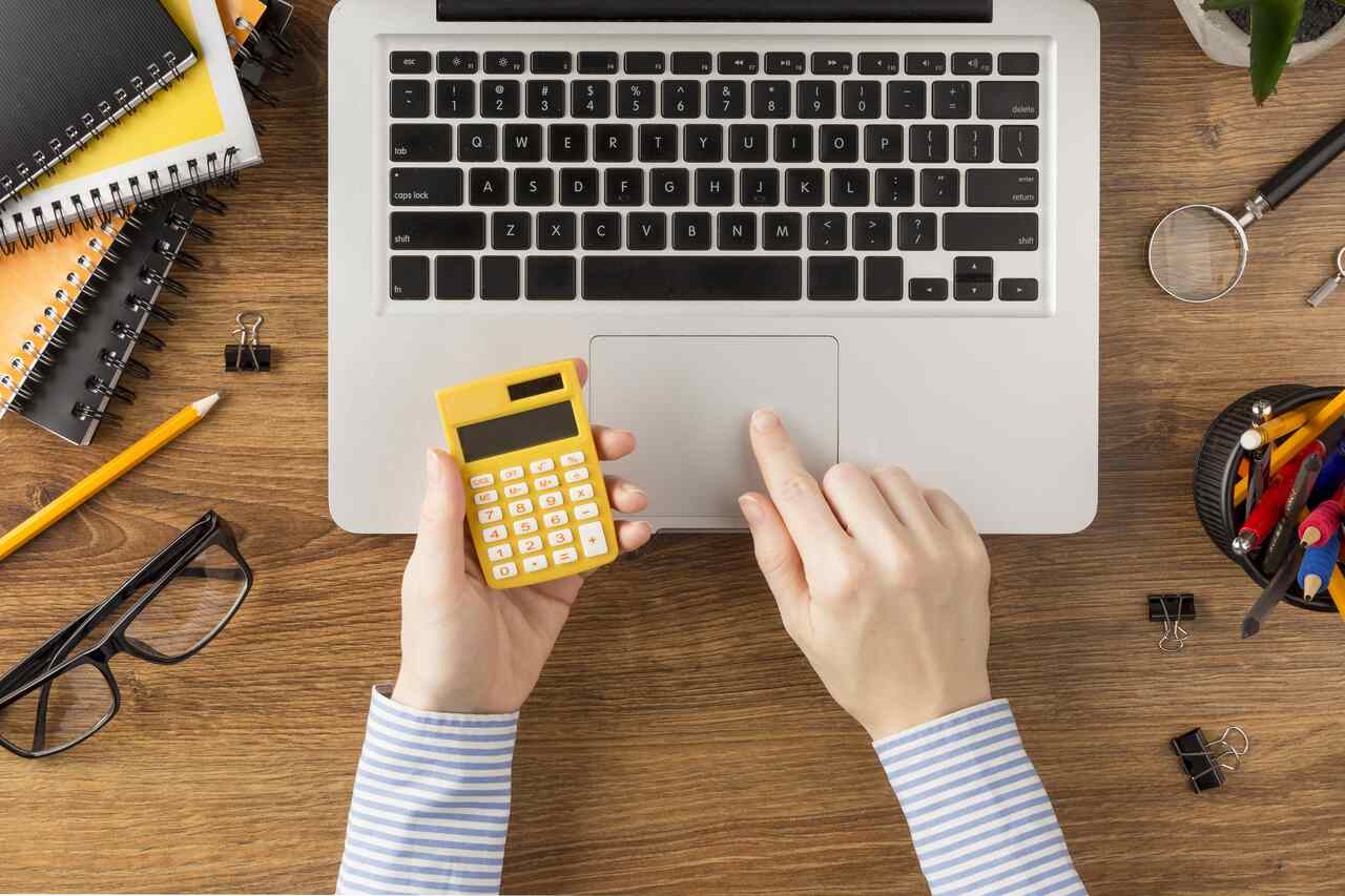 Homem com calculadora, óculo, notebook, agendas e canetas